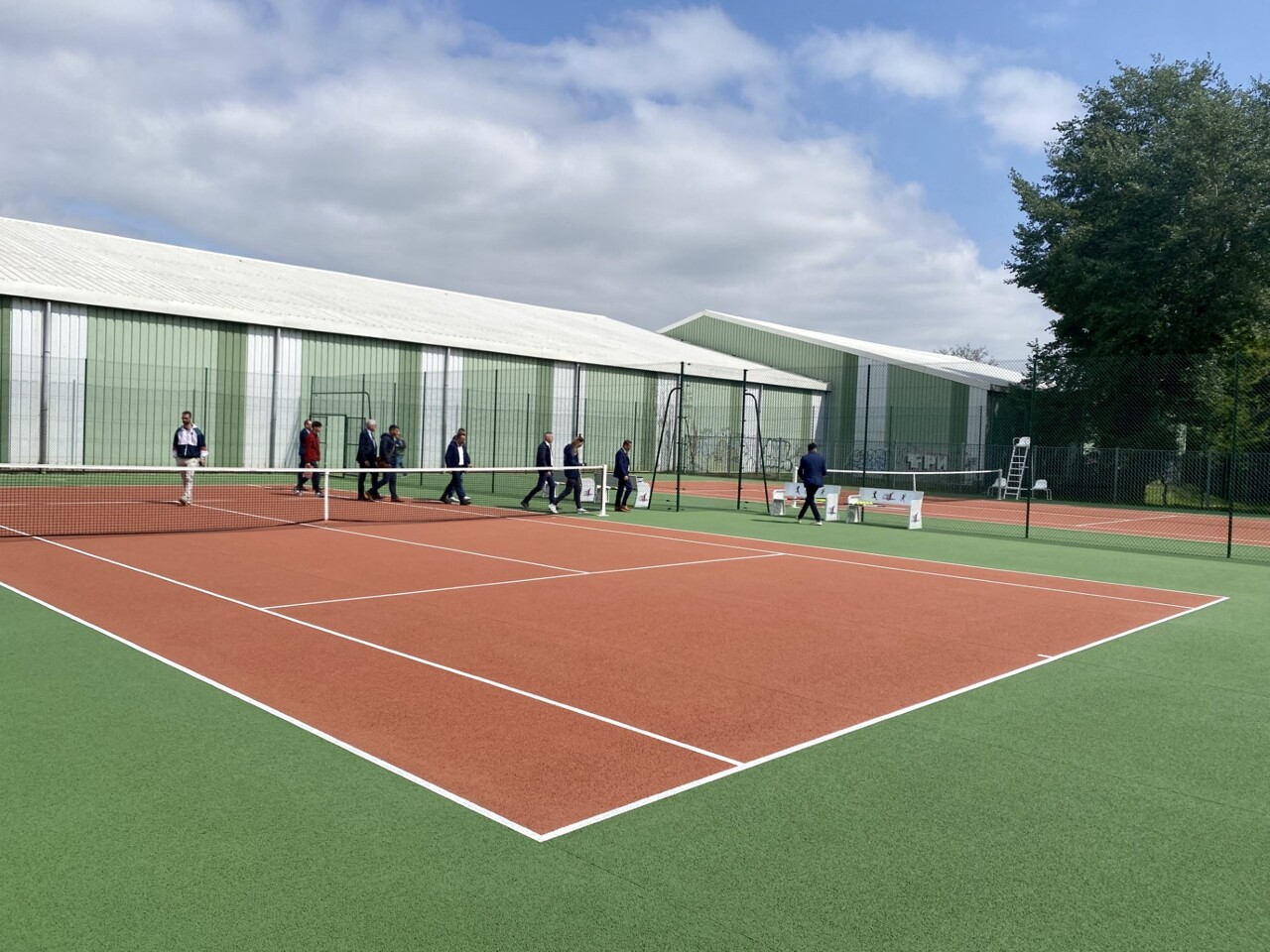 Terrain de tennis en libre accès dans un parc municipal avec filet et lignes blanches