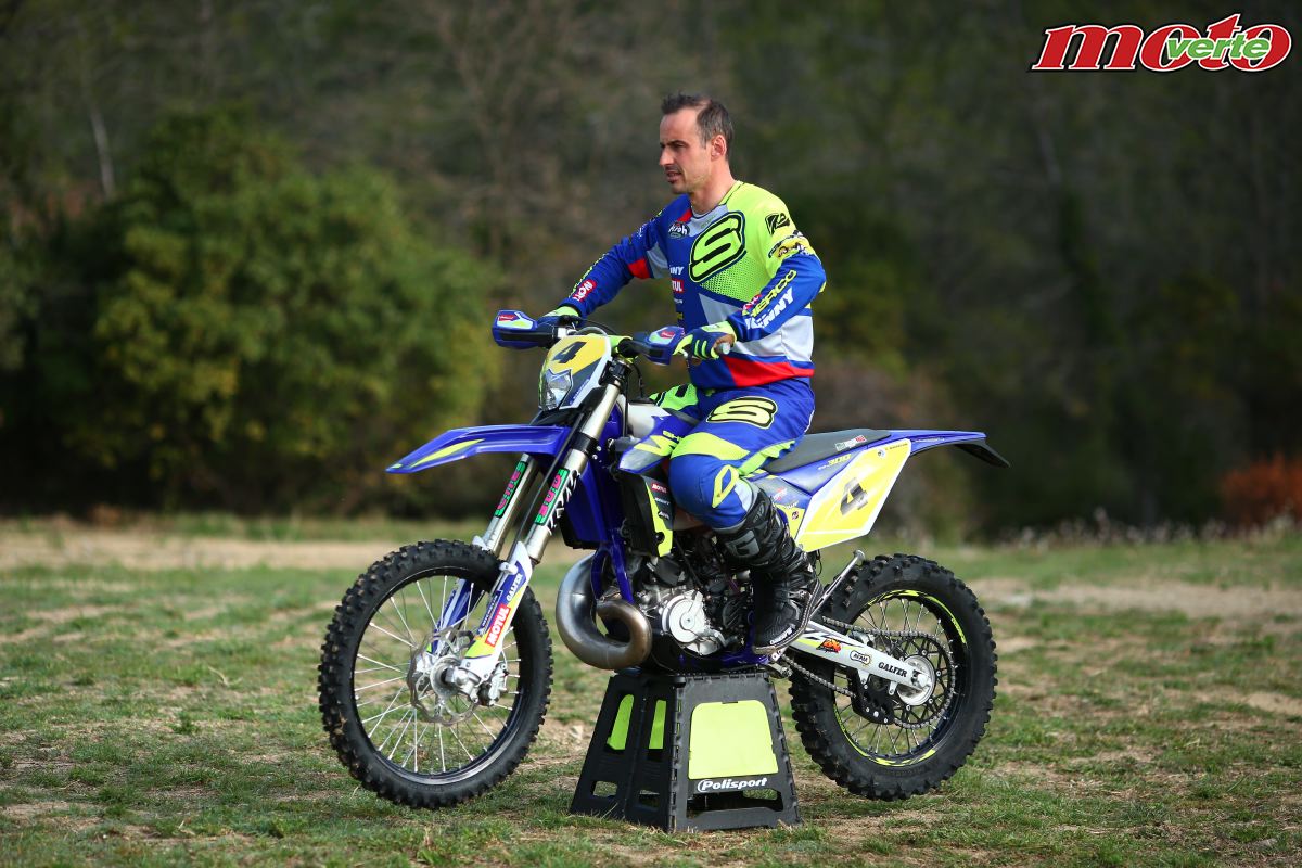 Pilote de moto enduro négociant une montée technique en sous-bois