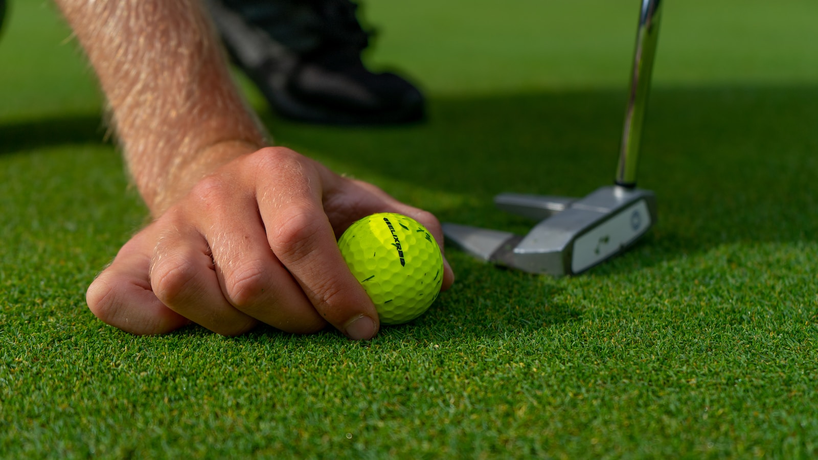 Joueur de golf réalisant un putting sur le green avec un putter